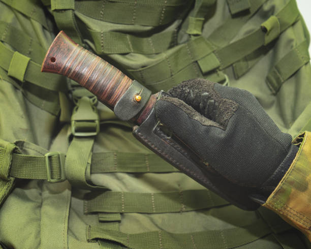istock a hand in a black army glove holds a knife 1198469238