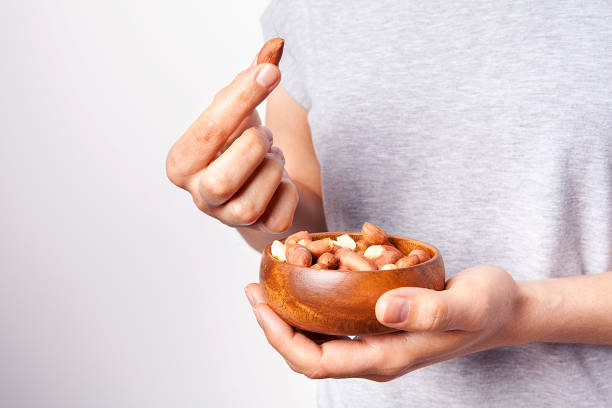 istock Woman's in hand peanut in a bowls. 1198469537