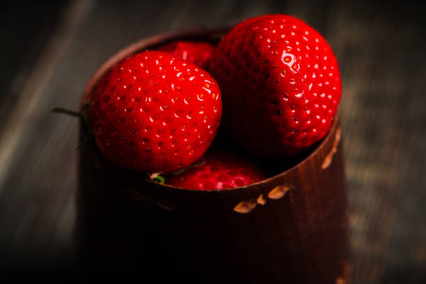 Ripe and juicy strawberries on the dark rustic background. Selective focus. Shallow depth of field.