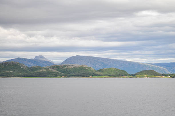View to the cloudy sky over the Norwegian sea and Vega archipelago mountains from a ferry deck in Helgeland, Norway on summer day