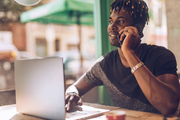 istock Man in coffee shop multi-tasking 1198474722