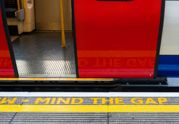 открыть вагон лондонского метро с mind the gap предупреждение на платформе - go английское слово стоковые фото и изображения