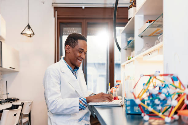 istock Male employee smiling and using laptop in industry 1198482620