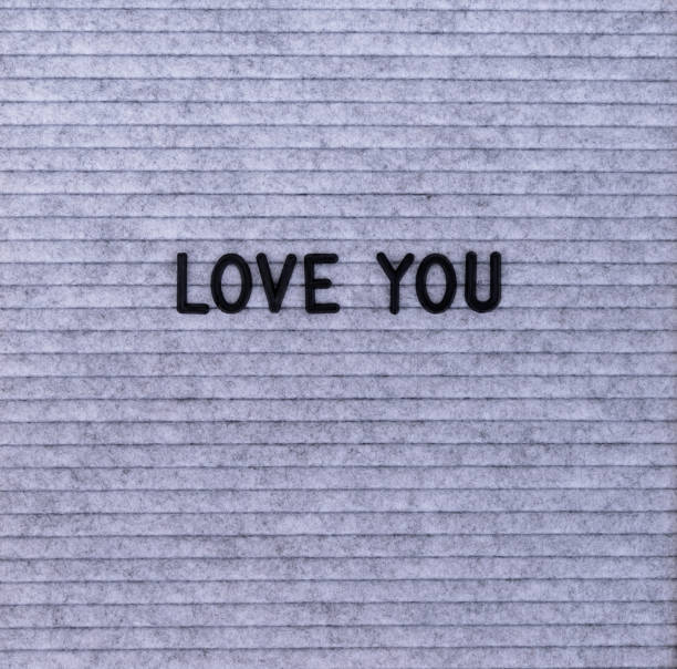The words Love You on grey felt letter board