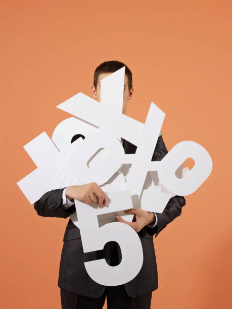 Businessman holding financial figures going crazy Studio shot of a young caucasian businessman holding large built numbers and financial figures i 5 stock pictures, royalty-free photos & images