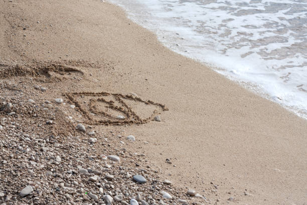 istock House with heart symol on a sandy beach 1198488987