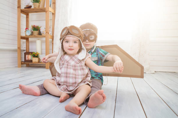istock Two little children wearing pilot costume and playing in the room. 1198490077