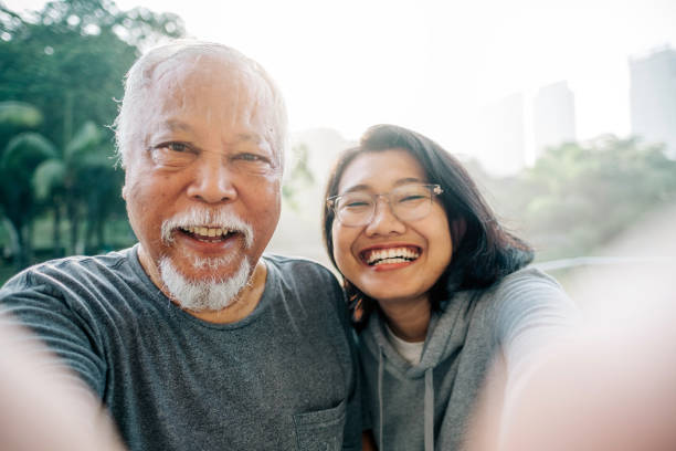 encantador padre mayor e hija tomando selfie juntos - park posing family outdoors fotografías e imágenes de stock