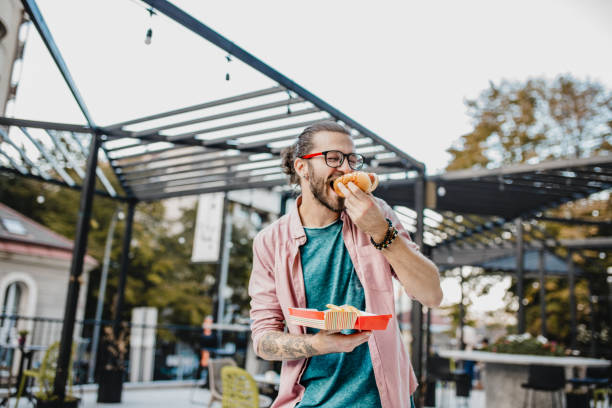 istock Young man is eating hot dog 1198497144