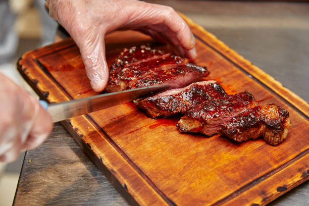 istock the cook cuts the fried boiled pork, into slices, lying on a board 1198497781