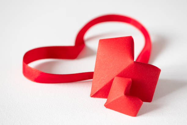 coeurs d'origami et rubans de satin sur le fond blanc dans la vue avant avec l'espace de copie. décor rouge de papier pour la saint-valentin ou le mariage. concept beau amour - valentines day origami romance love photos et images de collection