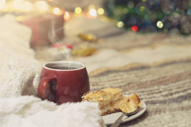 Cup of tea on a background of a Christmas tree with luminous lights