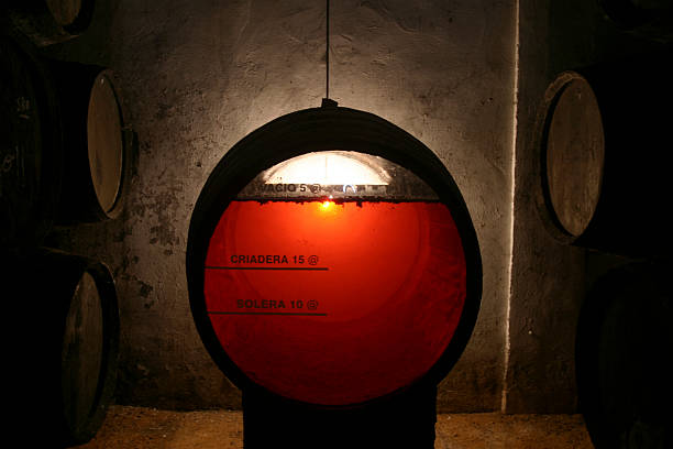 Clear sherry wine barrel in old brown cellar transparent sherry wine barrel in an old cellar in Jerez (Spain) to see the making of sherry wine. These barrels (sherry wine) are used after to aged scotch whiskey jerez de la frontera stock pictures, royalty-free photos & images
