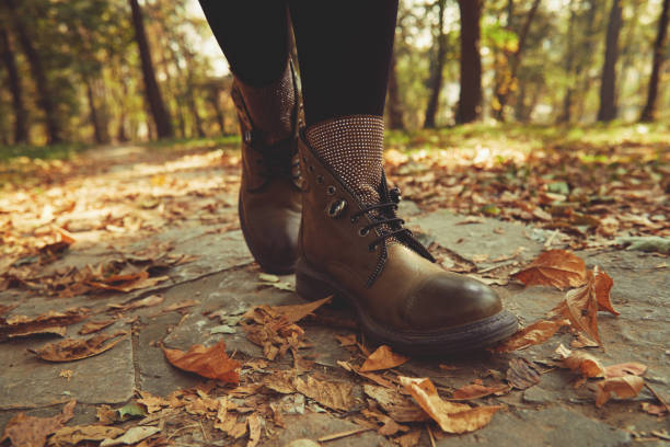 istock Women's legs standing in autumn leaves. 1198499081