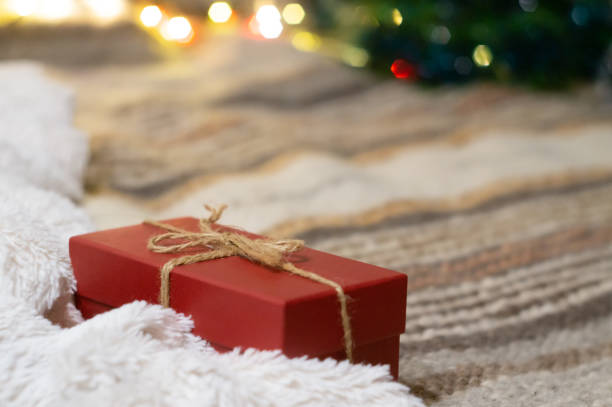 istock Gift box on the background of a Christmas tree with lights 1198499139