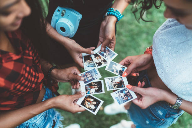 istock Happy girls making photos with instant camera 1198499419