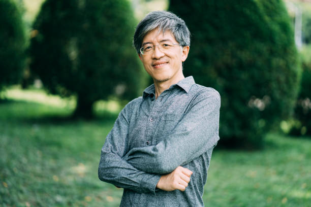 istock Asian man standing arms crossed in park 1198500430