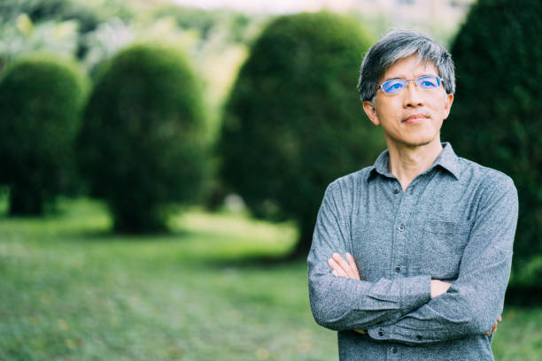 istock Asian man standing arms crossed in park 1198500434