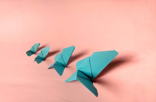 istock Blue paper butterflies on pink background. decorative concept 1198500466