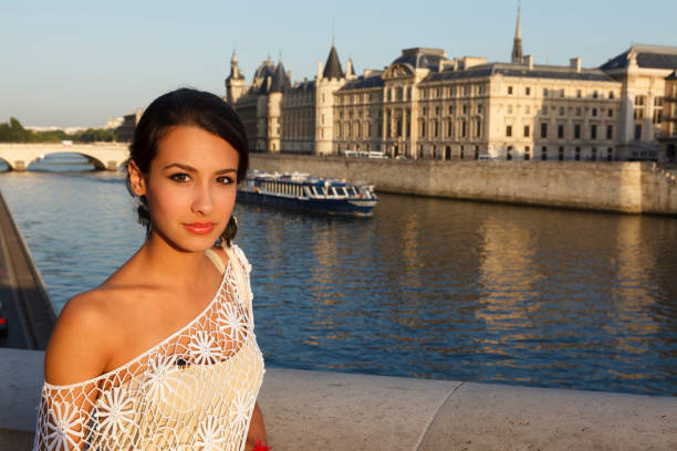 Beautiful young woman enjoying the sights of Paris by the River Seine at sunset.