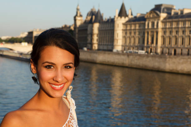 Beautiful young woman enjoying the sights of Paris by the River Seine at sunset.