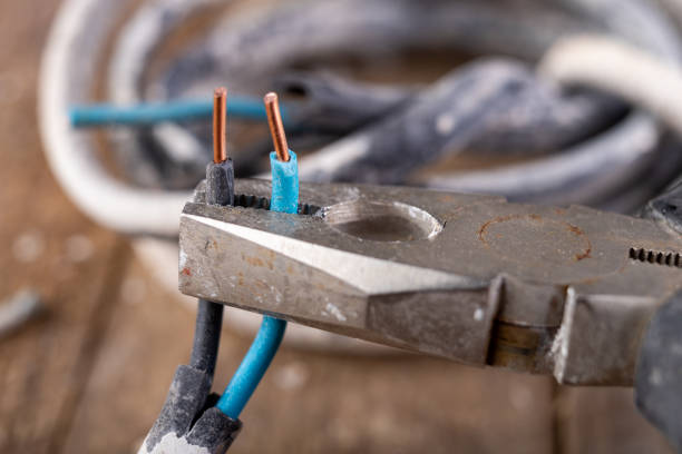 istock Old copper electric wire and combination pliers. Electrical installation repair. Dark background. 1198502892