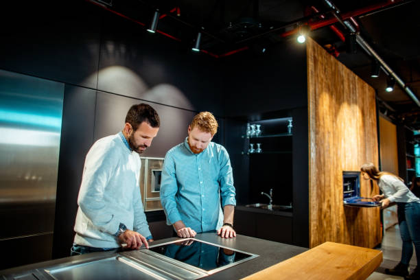 istock Shopper getting informed about new generation cooktop features by a salesman in a modern kitchen appliances store 1198503526