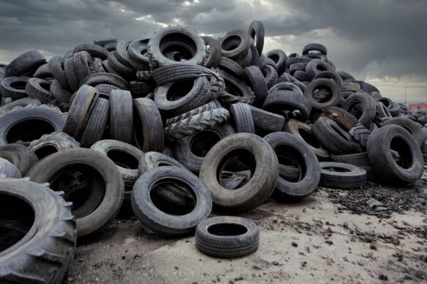 Industrial landfill for the processing of waste tires and rubber tyres. Pile of old tires and wheels for rubber recycling. Tyre dump stock photo