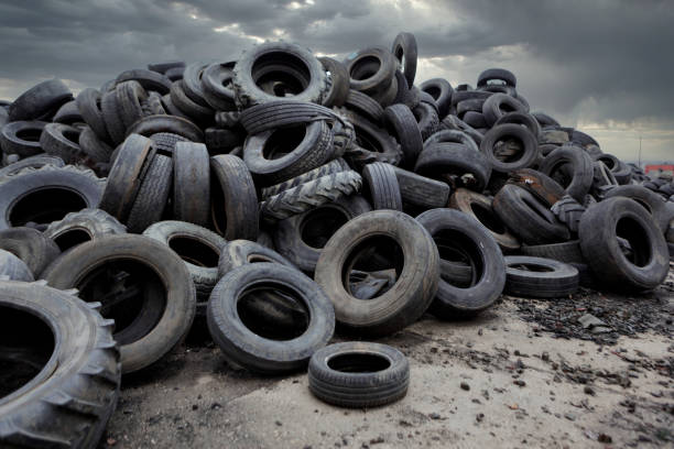 промышленная свалка для переработки отходов шин и резиновых шин. куча старых шин и колес для переработки резины. свалка шин - old tire стоковые фото и изображения