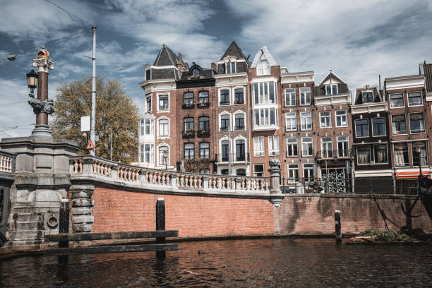 low angle view of amsterdam canal and it's buildings - magere brug photos et images de collection