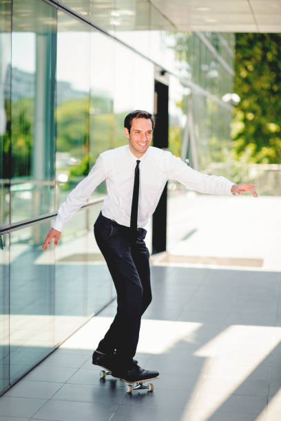 istock Handsome businessman riding skateboard 1198504752