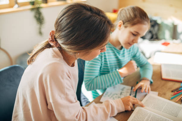 istock Private teacher helping girl doing homework 1198507736