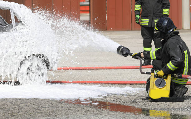 firefighter extinguishes a fire that broke out in a car with a foaming agent
