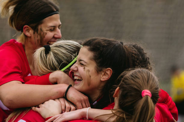 happy female soccer players celebrating goal - competición de fútbol fotografías e imágenes de stock