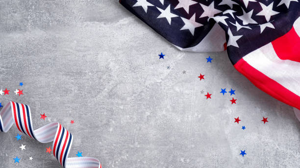 US American flags and confetti star on concrete stone background with copy space. Banner mockup for Presidents day, USA Memorial day, Veterans day, Labor day, or 4th of July celebration.