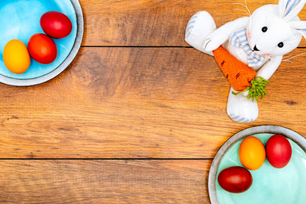 istock Six colourful Easter eggs on two plates and Easter bunny with wooden background 1198514308