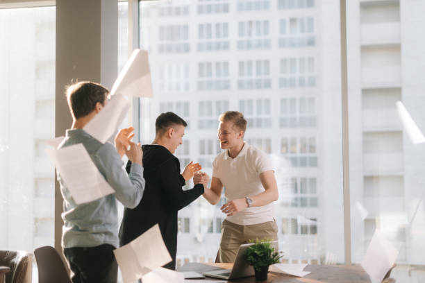 istock Successful business team are having fun throwing paper documents 1198515473