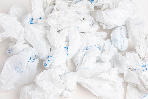 A close-up of a spread of white crumpled grocery labeled plastic bags.