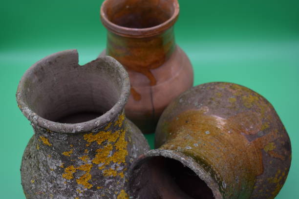 istock Old clay pots are covered with mold on a green background. 1198522204