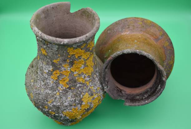 istock Old clay pots are covered with mold on a green background. 1198522211