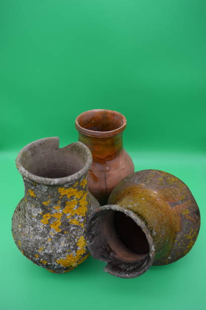 istock Old clay pots are covered with mold on a green background. 1198522217