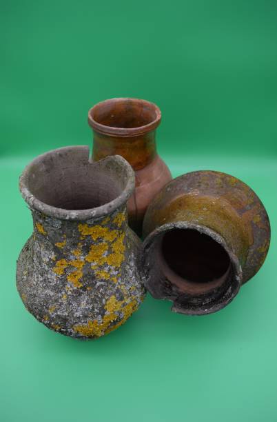 istock Old clay pots are covered with mold on a green background. 1198522234