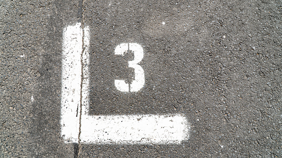 A close view of the white painted numbers on the concrete pavement.