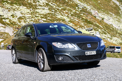 Saint Gotthard Pass, Switzerland - September 13, 2019: Family estate car Seat Exeo at the background of the Alps.