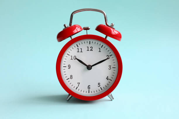 istock Red alarm clock on turquoise background shows 1198532399