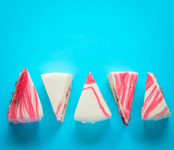 istock Strawberry cake slices, in a pattern on a blue background. symmetrically displayed.  cheesecake portions. 1198532511