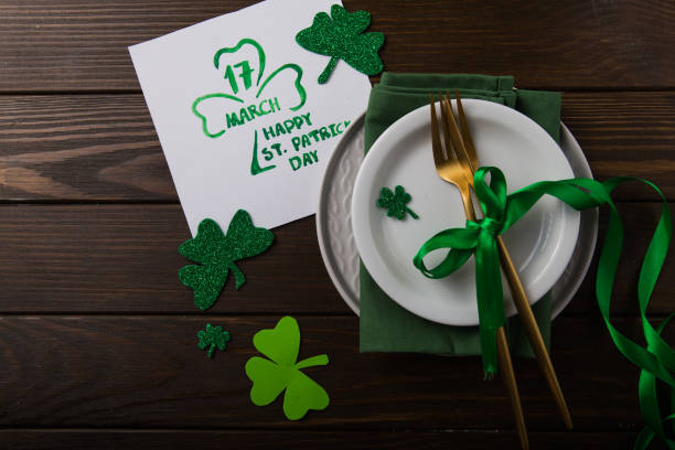 istock St Patrick's Day party table setting decorated with green leprechaun on wooden background. 1198532529