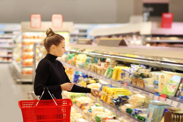 mujer comprando en supermercado leyendo información de productos. - supermarket meat women packaging fotografías e imágenes de stock