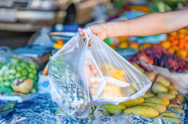 Woman's hand holding fruit bags