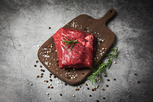 Raw beef steak with herb and spices / Fresh meat beef sliced on wooden cutting board background